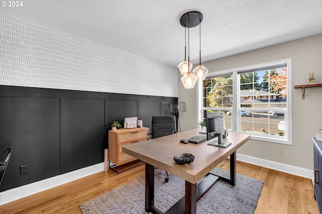 office area with a textured ceiling and light hardwood / wood-style flooring