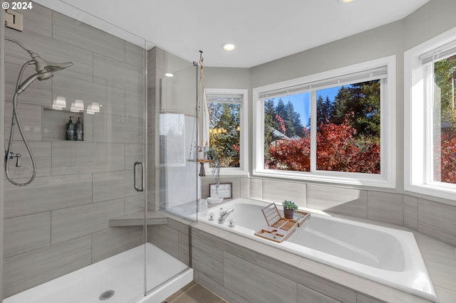 bathroom featuring plenty of natural light and independent shower and bath