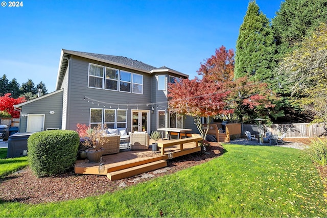 back of house featuring outdoor lounge area, a deck, and a lawn