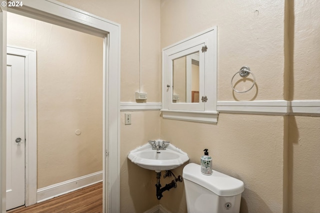 bathroom with sink, toilet, and hardwood / wood-style floors