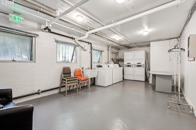 basement with washing machine and dryer, white fridge with ice dispenser, stacked washer / dryer, and sink