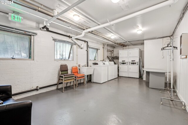 basement featuring stacked washer and clothes dryer, sink, and washer and clothes dryer