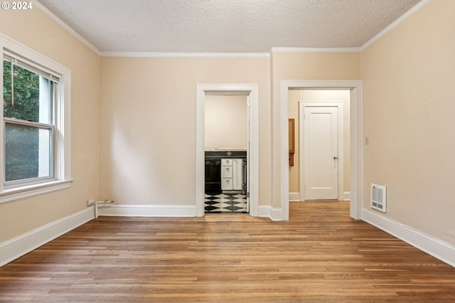 unfurnished room with ornamental molding, light hardwood / wood-style flooring, and a textured ceiling