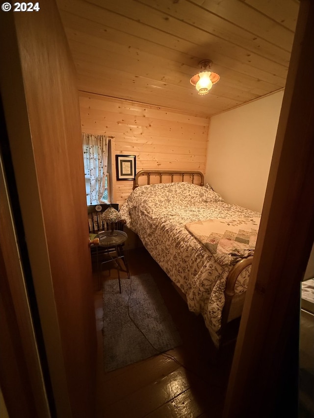 bedroom with wood ceiling and wood walls