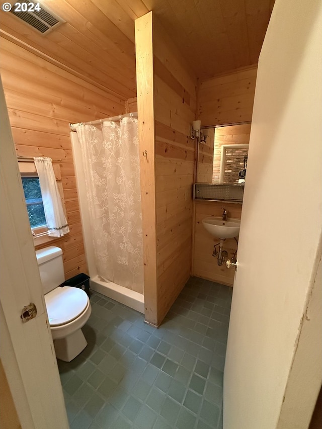 bathroom featuring wood walls, toilet, and walk in shower