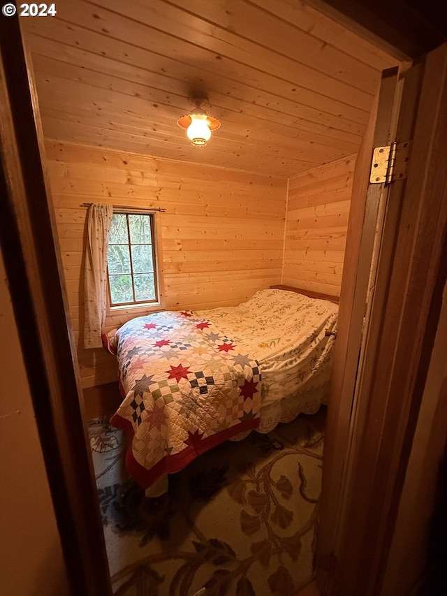 bedroom featuring wooden ceiling and wood walls