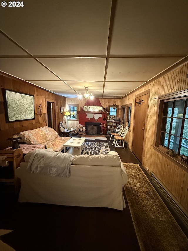 interior space with a paneled ceiling and wood walls