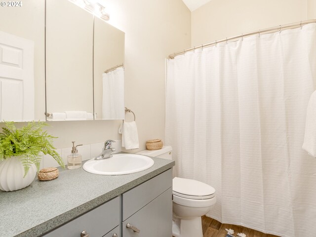 bathroom with vanity, hardwood / wood-style floors, and toilet