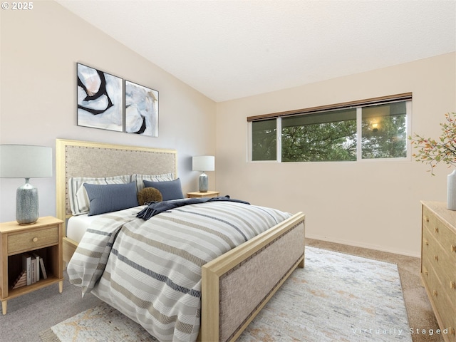 bedroom featuring light colored carpet and lofted ceiling