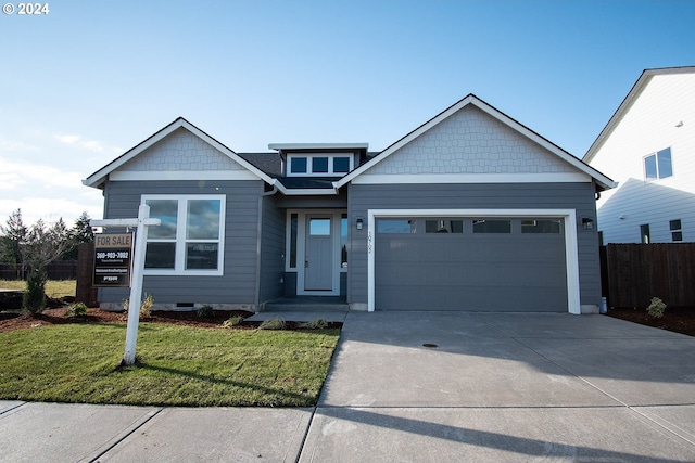 craftsman-style home featuring a garage and a front lawn