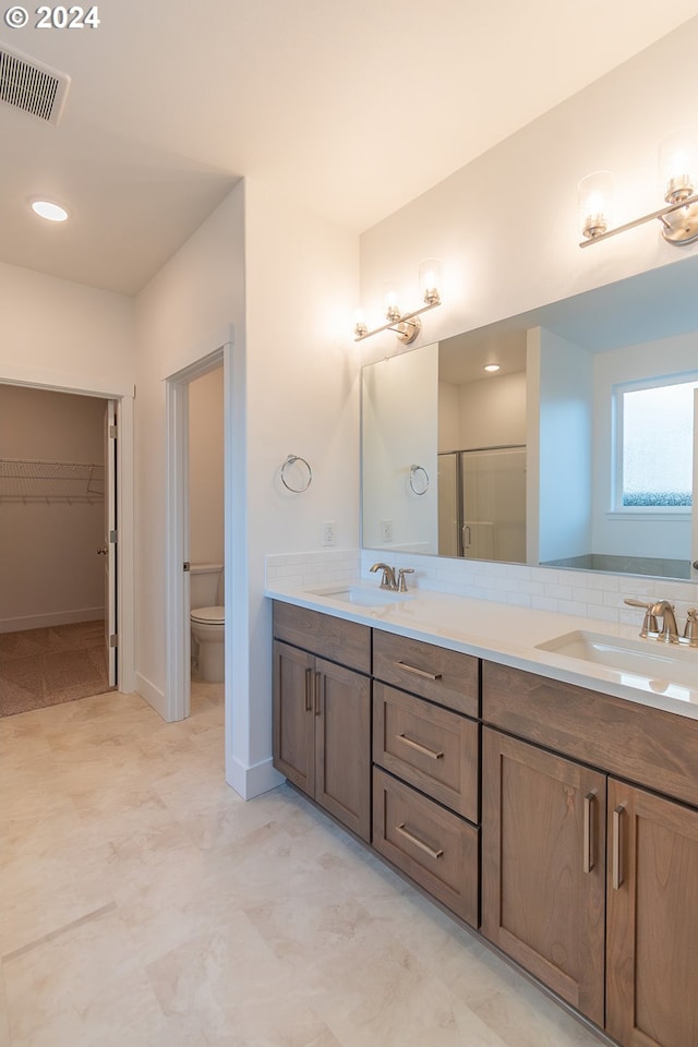 bathroom with vanity, a shower with shower door, and toilet