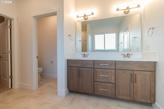 bathroom with decorative backsplash, vanity, and toilet