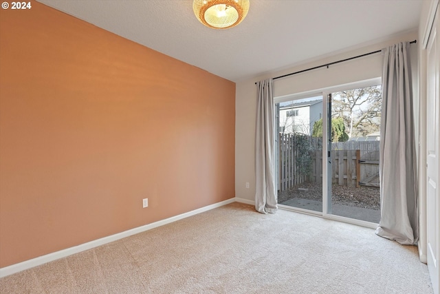 carpeted empty room with lofted ceiling, a textured ceiling, and baseboards