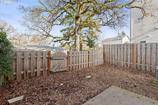 view of yard featuring a fenced backyard and a gate