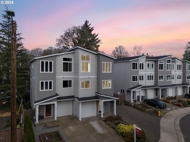 view of property with a garage, driveway, and a residential view