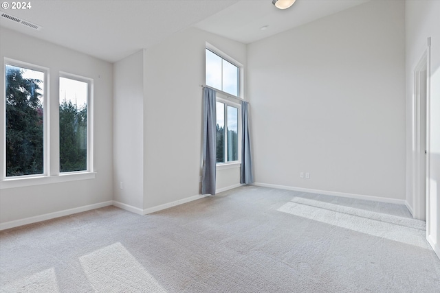 carpeted spare room with visible vents and baseboards