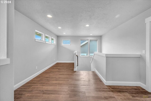 hallway featuring dark wood-type flooring and a textured ceiling