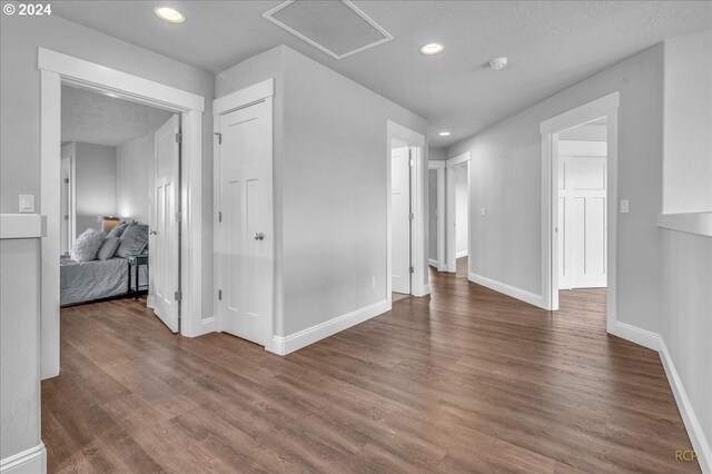 bedroom featuring hardwood / wood-style flooring, a textured ceiling, a brick fireplace, access to outside, and a raised ceiling