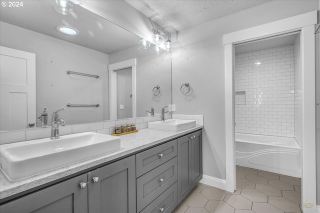 bathroom featuring tiled shower / bath, tile patterned floors, vanity, and a textured ceiling