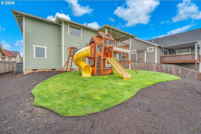 rear view of property featuring a playground and a yard