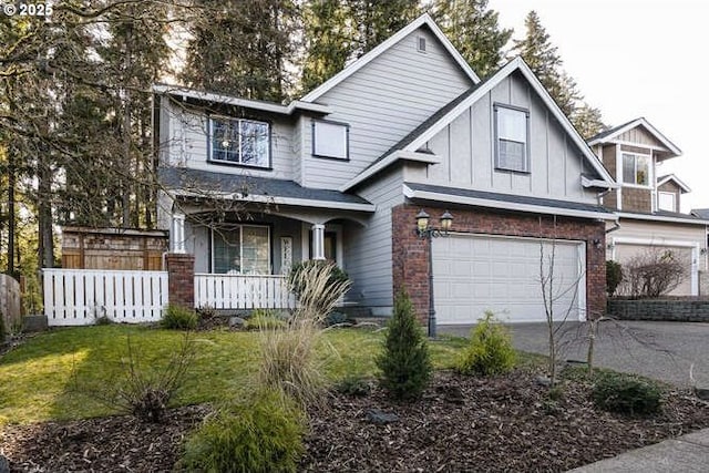 view of front of property with a garage, a front yard, and a porch