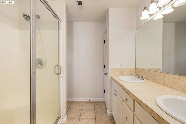 bathroom featuring walk in shower, vanity, and tile patterned flooring