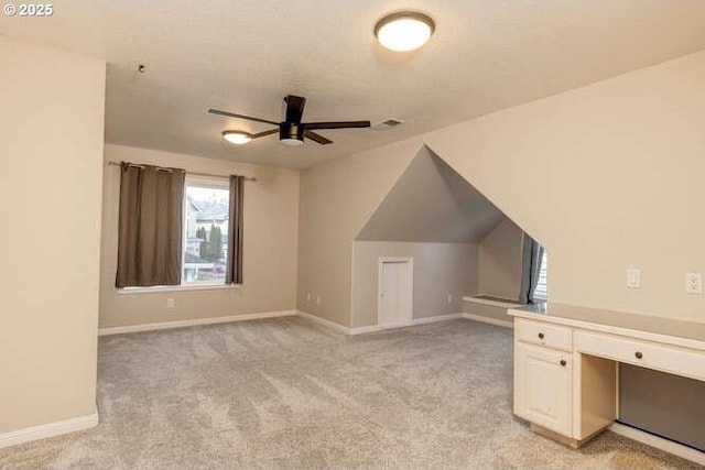 additional living space featuring ceiling fan and light carpet