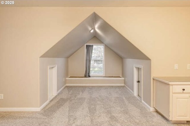 bonus room featuring vaulted ceiling and light carpet