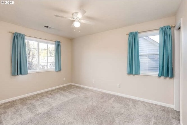 carpeted spare room with plenty of natural light and ceiling fan