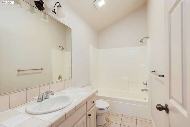 full bathroom featuring lofted ceiling, washtub / shower combination, tile patterned floors, vanity, and toilet