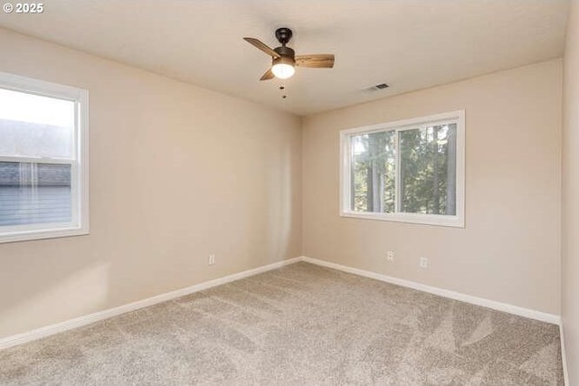 carpeted spare room with plenty of natural light and ceiling fan