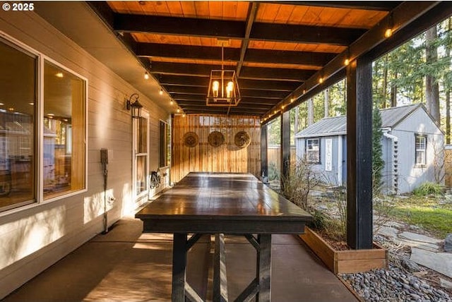 sunroom / solarium featuring beamed ceiling and wooden ceiling