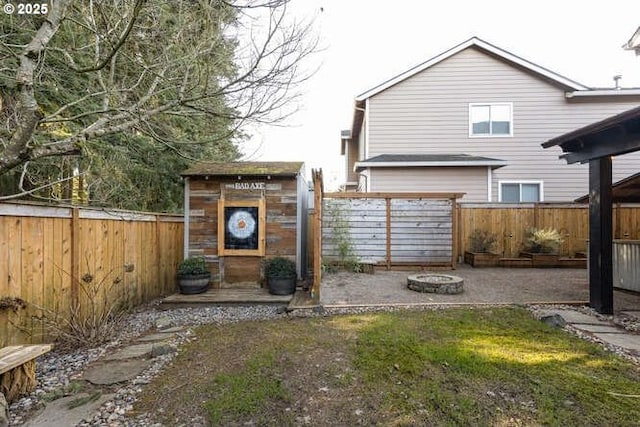 rear view of property featuring an outdoor fire pit, a patio, and a shed