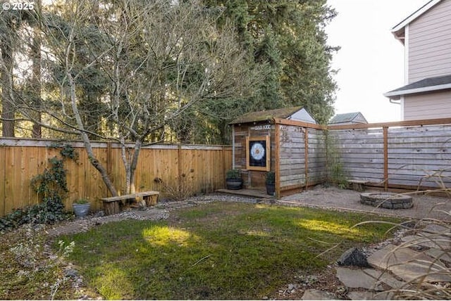 view of yard featuring a fire pit and a shed