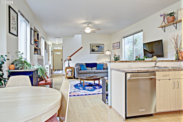 kitchen featuring light hardwood / wood-style flooring, stainless steel dishwasher, light brown cabinetry, and ceiling fan