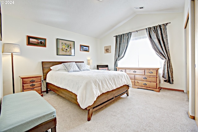 bedroom with vaulted ceiling and light colored carpet