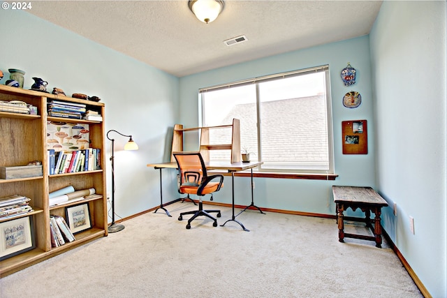 office featuring a textured ceiling and light carpet