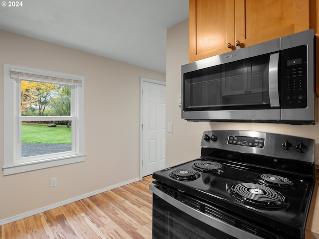 kitchen featuring black electric range and light hardwood / wood-style flooring