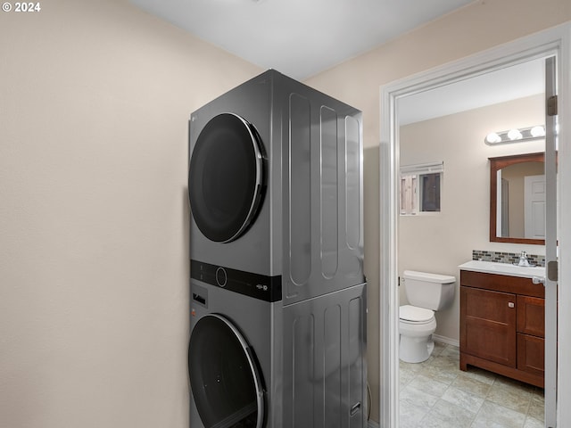 laundry area featuring stacked washing maching and dryer and sink