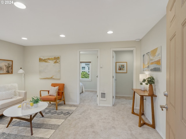 living area with heating unit and light carpet