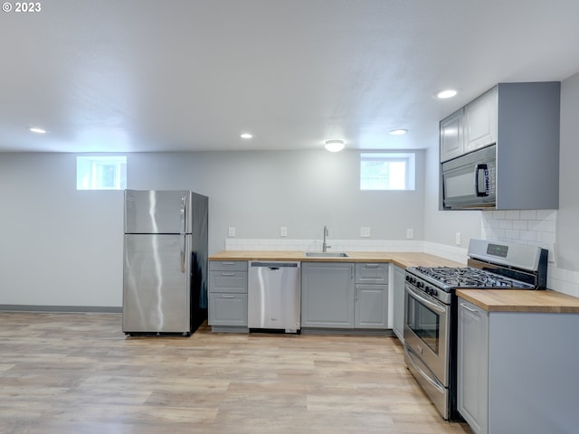 kitchen featuring sink, wooden counters, a wealth of natural light, and stainless steel appliances