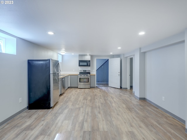 kitchen with light hardwood / wood-style flooring, appliances with stainless steel finishes, and gray cabinets