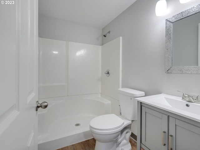 bathroom featuring vanity, toilet, walk in shower, and hardwood / wood-style flooring