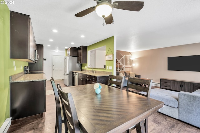 dining area featuring a baseboard radiator, sink, dark hardwood / wood-style floors, and ceiling fan