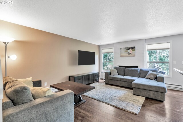 living room featuring dark hardwood / wood-style floors, a healthy amount of sunlight, and a textured ceiling