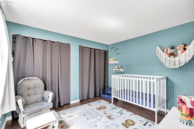 bedroom featuring a nursery area and hardwood / wood-style floors