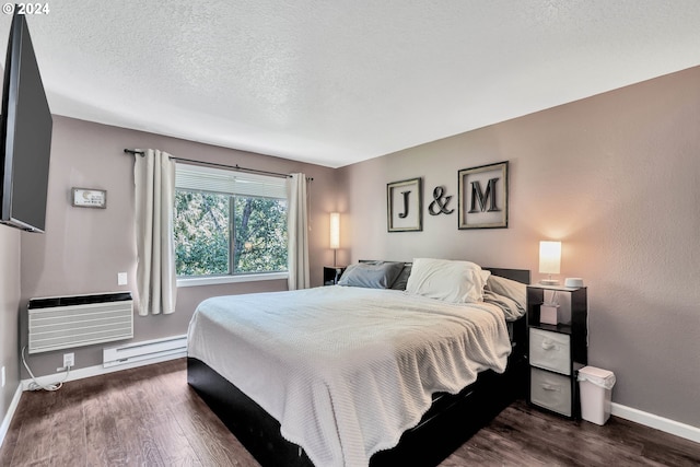 bedroom with a wall mounted air conditioner, dark hardwood / wood-style flooring, a textured ceiling, and a baseboard heating unit