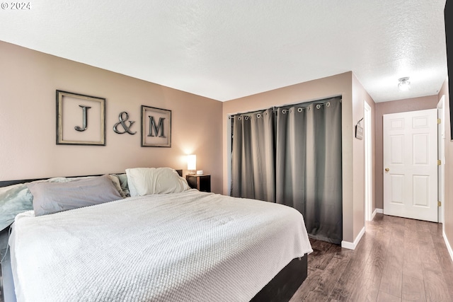 bedroom with a textured ceiling and hardwood / wood-style floors