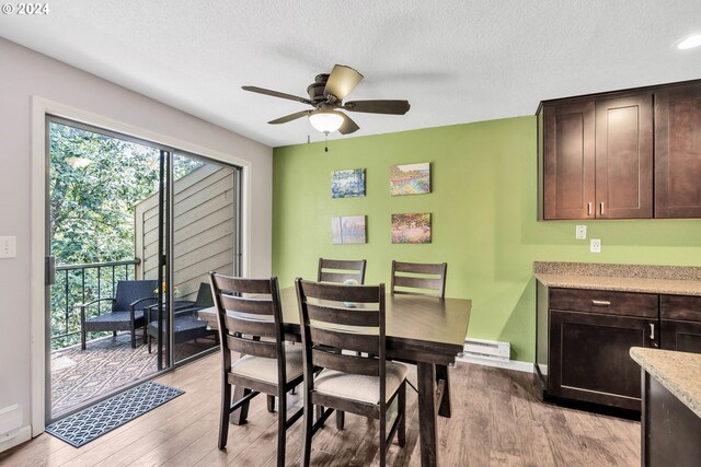 dining room featuring ceiling fan, a textured ceiling, light hardwood / wood-style flooring, and a baseboard heating unit