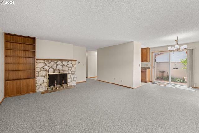 unfurnished living room with a textured ceiling, light colored carpet, a notable chandelier, and a fireplace